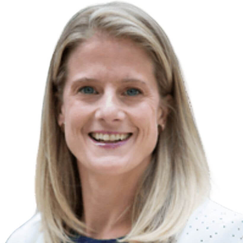 A woman with straight, shoulder-length blonde hair smiles at the camera. She is wearing a white blazer and a dark top, set against a plain white background.