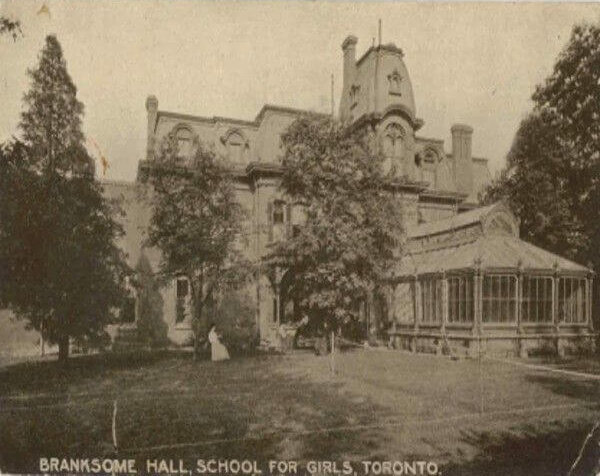 A sepia-toned historic photo of Branksome Hall, a girls’ school in Toronto, showing a large Victorian-style building surrounded by trees and a grassy lawn. The building has a greenhouse-like extension.