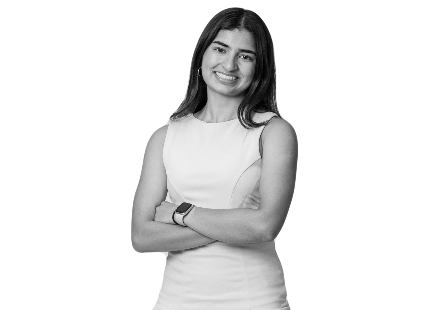 A woman with long hair stands smiling with her arms crossed, wearing a sleeveless dress and a smartwatch, on a plain white background.
