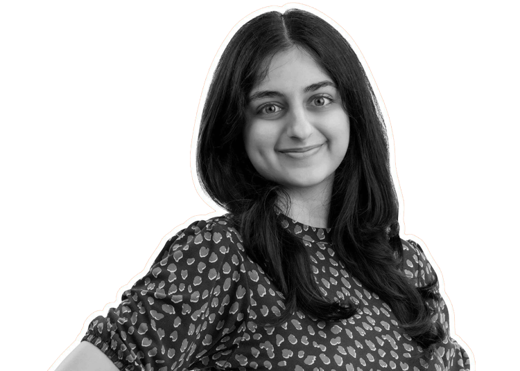 A young woman with long dark hair, wearing a patterned blouse, smiles warmly at the camera. The image is in black and white, with a white outline around her and a plain black background.