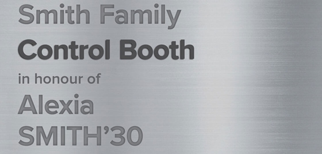 A brushed metal plaque reads: “Smith Family Control Booth in honour of Alexia SMITH ’30” with some words in bold.